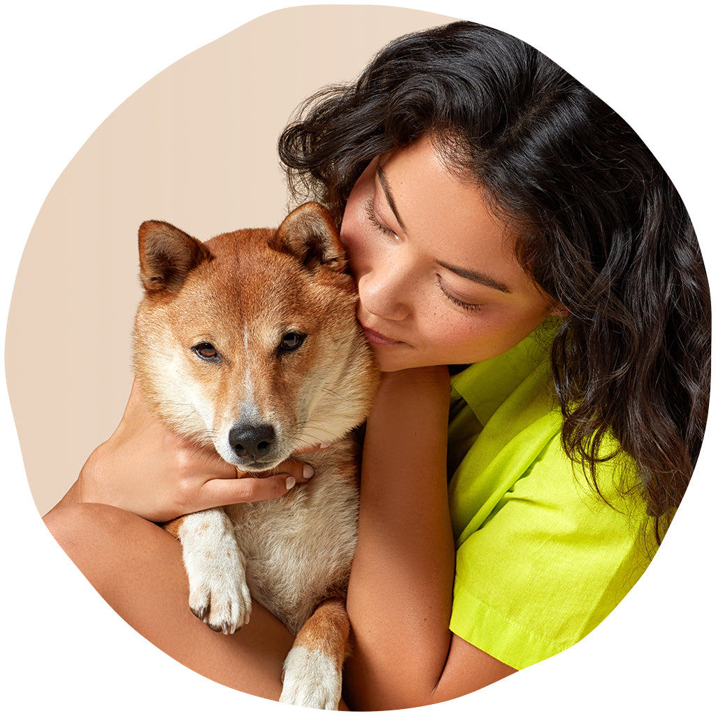 Woman holding a dog in her lap, cuddling it